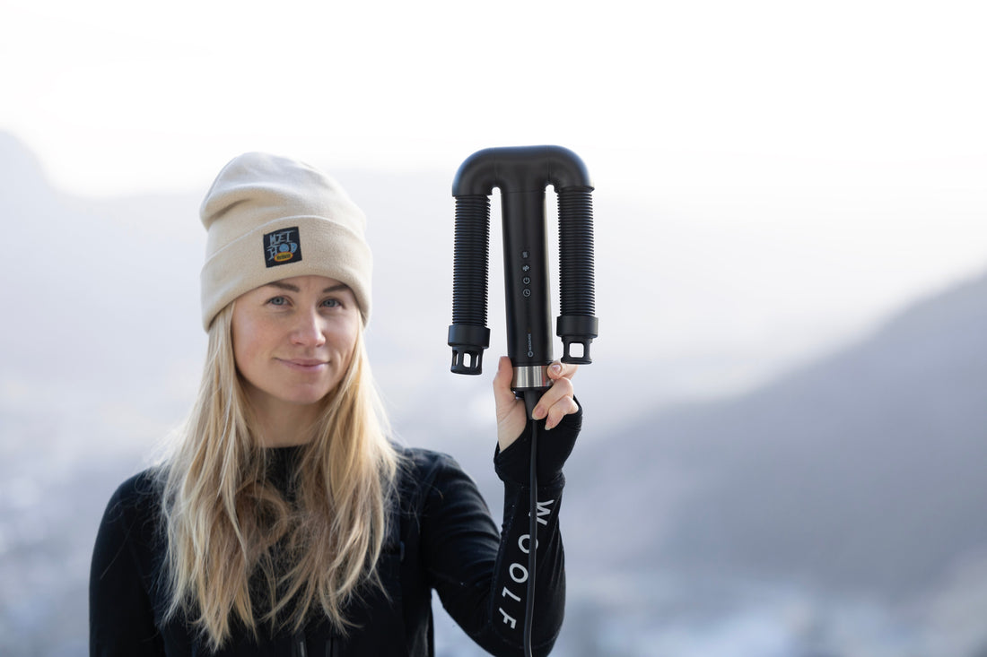 Woman holds Hedgehog GO dual-purpose travel-friendly boot and hair dryer